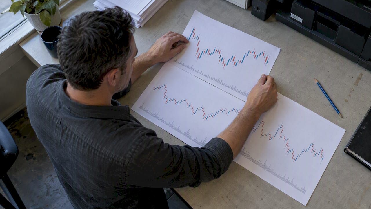 Analyst comparing printed forex candlestick charts