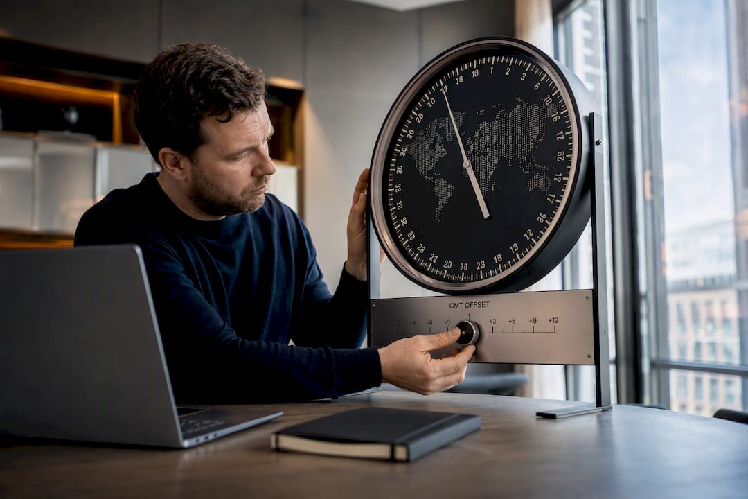 Hands adjusting GMT offset on world clock